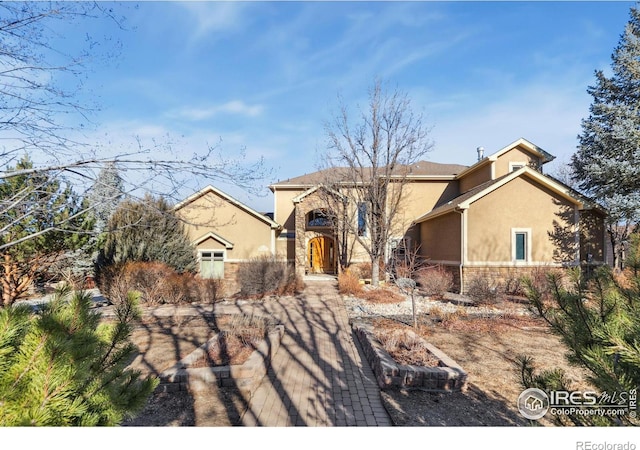 view of front of house featuring stone siding and stucco siding