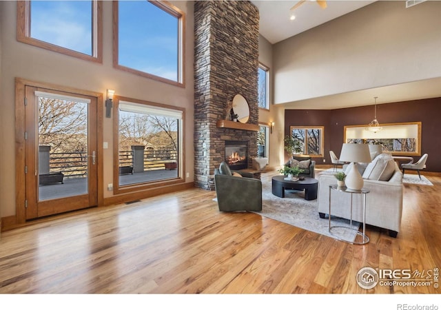 living room with visible vents, a fireplace, and wood finished floors