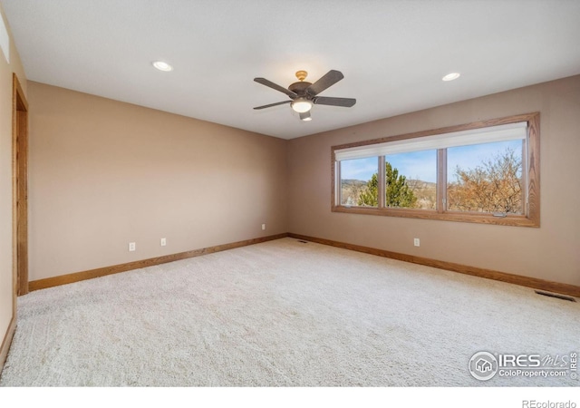 spare room with carpet floors, recessed lighting, visible vents, and baseboards