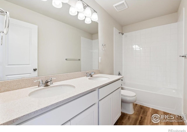 full bathroom featuring vanity, wood-type flooring, toilet, and washtub / shower combination