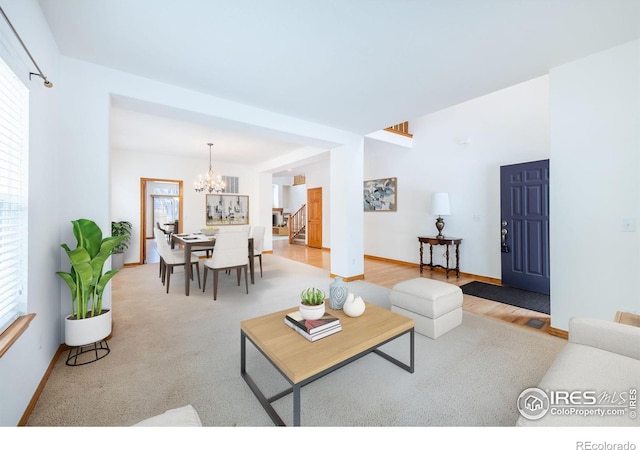 living room featuring a healthy amount of sunlight, a notable chandelier, and light hardwood / wood-style floors