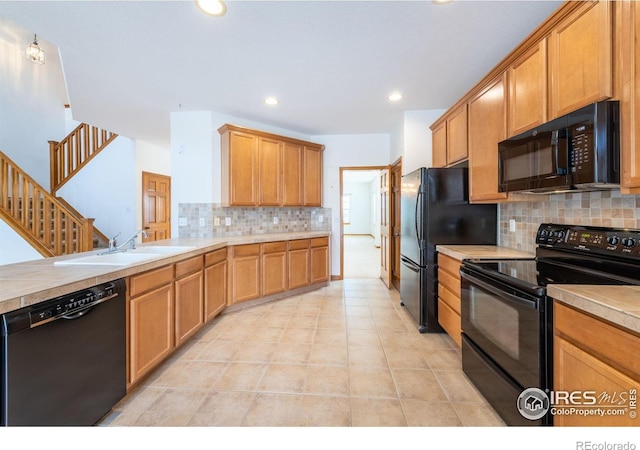 kitchen with backsplash, light tile patterned flooring, sink, and black appliances