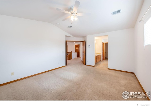 empty room with vaulted ceiling, light colored carpet, and ceiling fan