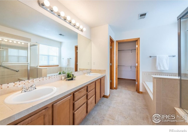 bathroom with vanity and separate shower and tub