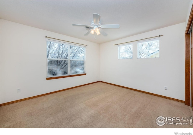 carpeted spare room featuring ceiling fan