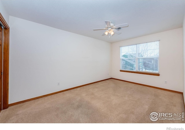 carpeted spare room featuring ceiling fan