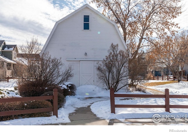 snow covered property featuring an outdoor structure