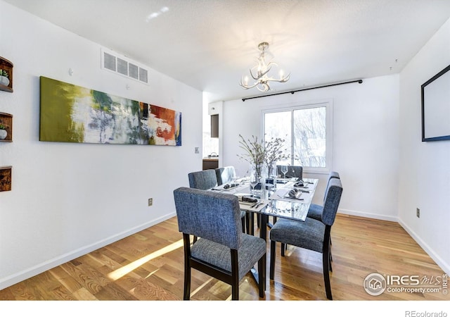 dining area featuring a chandelier and light hardwood / wood-style flooring