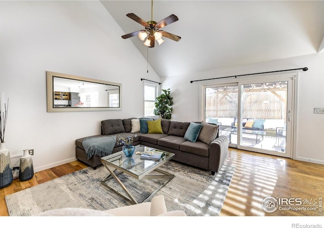 living room featuring ceiling fan, high vaulted ceiling, and light hardwood / wood-style floors