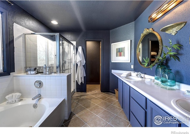 bathroom with tile patterned flooring, vanity, a textured ceiling, and separate shower and tub