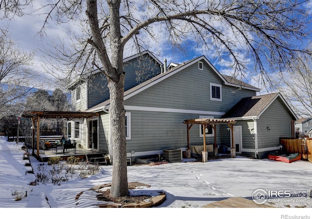 snow covered property with a pergola and a deck