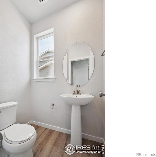 bathroom with sink, toilet, and hardwood / wood-style floors