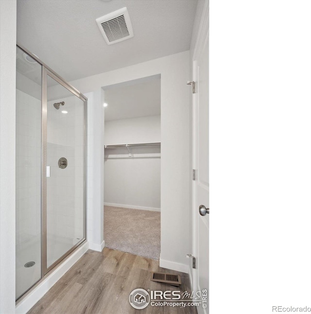 bathroom featuring a shower with door and hardwood / wood-style floors