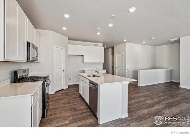 kitchen featuring a kitchen island with sink, sink, stainless steel appliances, and white cabinets