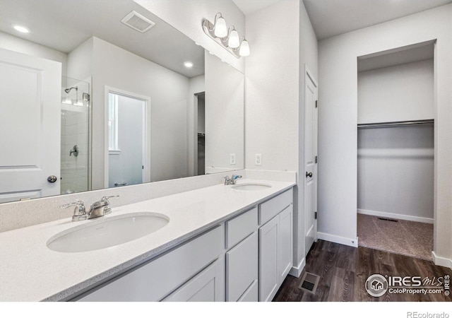 bathroom with wood-type flooring, vanity, and a shower with shower door