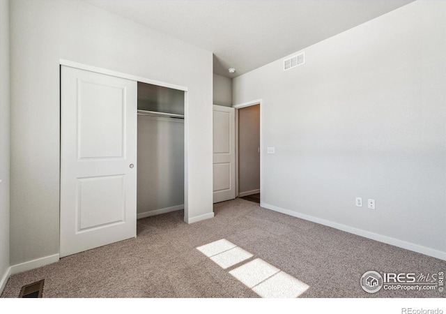 unfurnished bedroom featuring a closet and light carpet