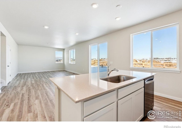 kitchen with sink, light hardwood / wood-style flooring, dishwasher, an island with sink, and white cabinets