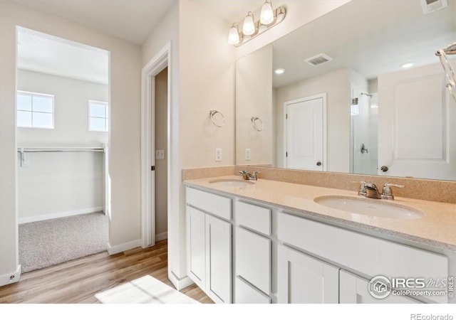 bathroom with vanity, a shower with shower door, and wood-type flooring