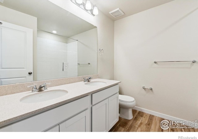 bathroom featuring vanity, hardwood / wood-style flooring, and toilet