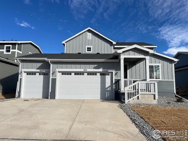 834 Mesic Ln, Windsor, CO 80550 - view of front of house featuring board and batten siding, a garage, and driveway