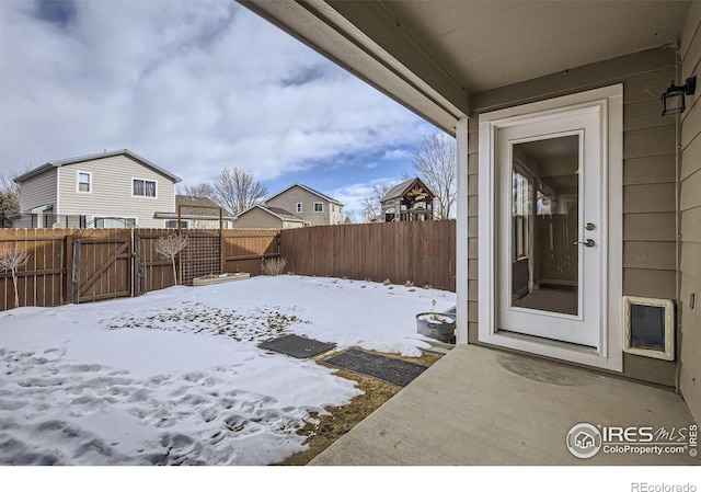 snowy yard with a fenced backyard