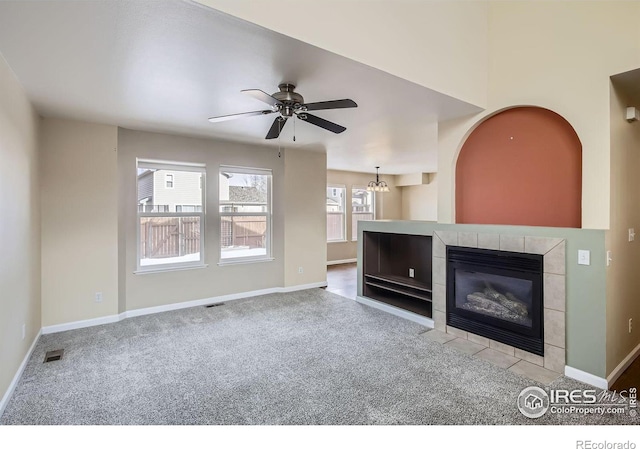 unfurnished living room featuring a fireplace, carpet flooring, visible vents, and baseboards