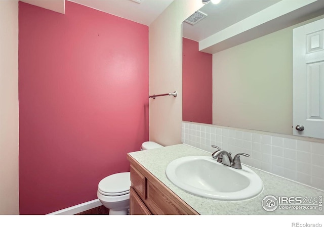 bathroom with visible vents, backsplash, toilet, and vanity