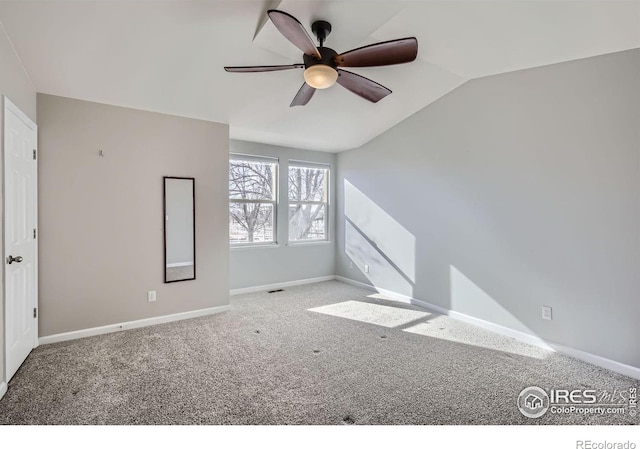 carpeted spare room featuring lofted ceiling, ceiling fan, visible vents, and baseboards