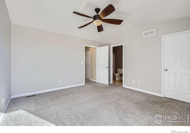 unfurnished bedroom featuring lofted ceiling, carpet floors, visible vents, and baseboards