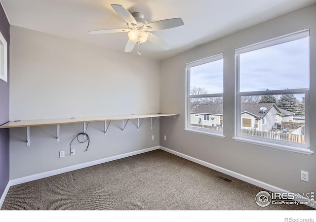 carpeted empty room featuring visible vents, baseboards, and a ceiling fan