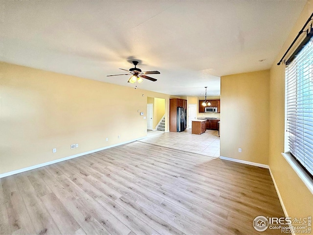 unfurnished living room with ceiling fan and light wood-type flooring