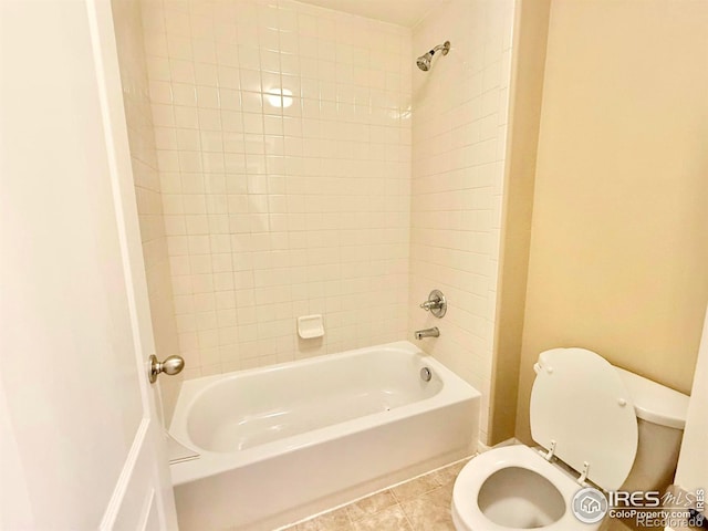 bathroom featuring tile patterned floors, toilet, and tiled shower / bath