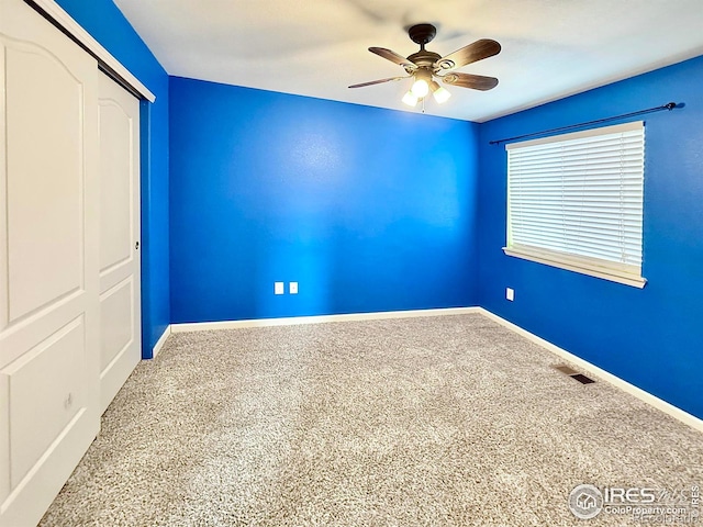 unfurnished bedroom with carpet, ceiling fan, and a closet