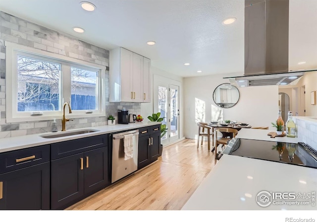 kitchen featuring white cabinetry, sink, decorative backsplash, island exhaust hood, and stainless steel dishwasher