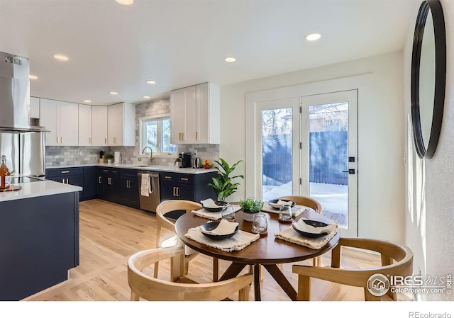 kitchen featuring sink, blue cabinetry, appliances with stainless steel finishes, white cabinetry, and backsplash