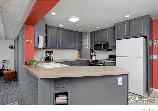 kitchen with sink, white refrigerator, gray cabinets, kitchen peninsula, and oven