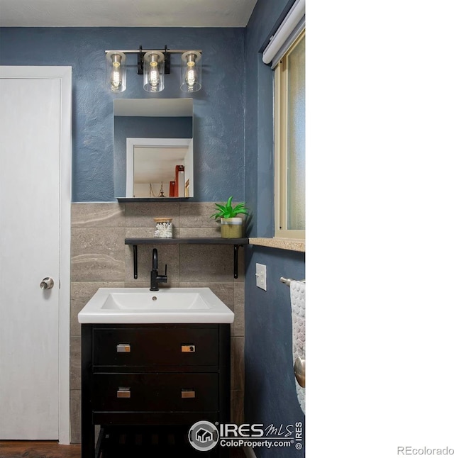 bathroom featuring vanity and tile walls