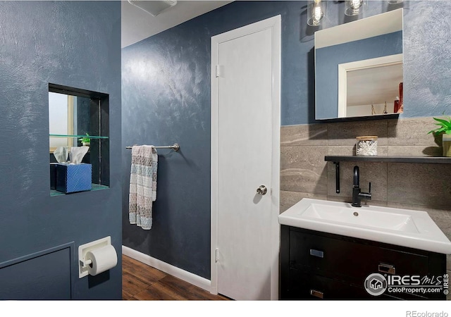 bathroom featuring vanity, hardwood / wood-style flooring, and decorative backsplash