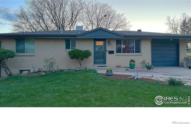 ranch-style home with a garage and a front lawn