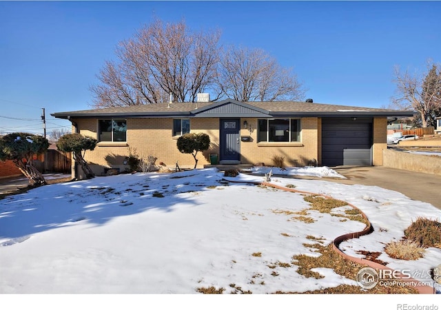 ranch-style house with brick siding, driveway, a garage, and fence