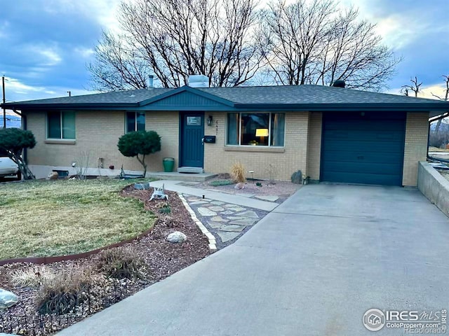 ranch-style home with concrete driveway, brick siding, and a garage