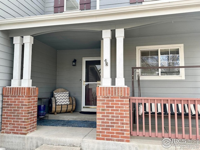 view of exterior entry featuring covered porch