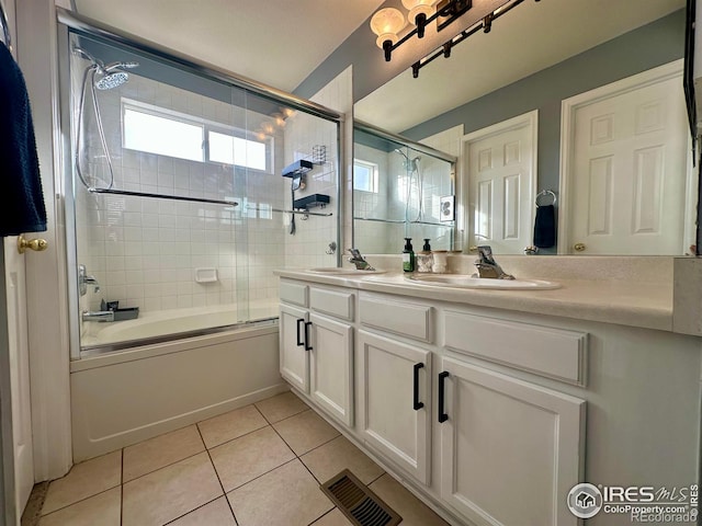 bathroom with tile patterned flooring, vanity, and bath / shower combo with glass door