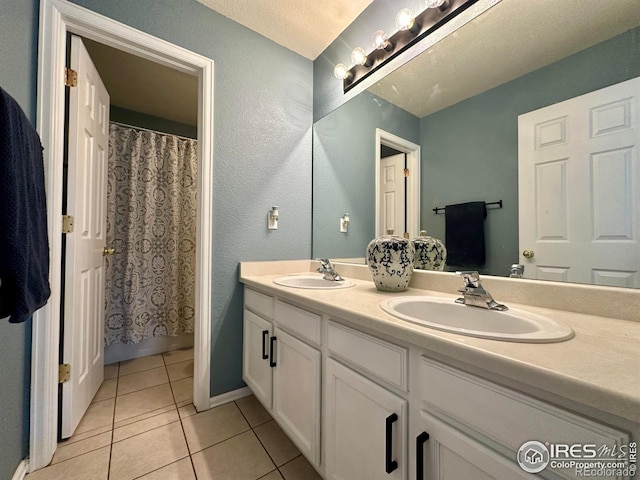 bathroom featuring tile patterned flooring, vanity, and walk in shower