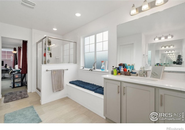 bathroom with walk in shower, vanity, and hardwood / wood-style flooring