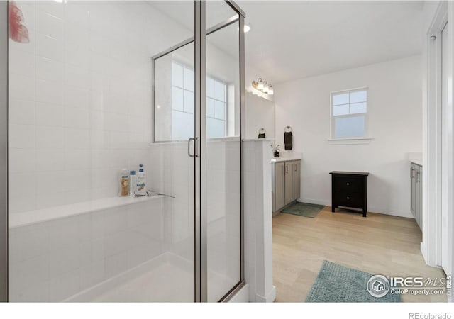 bathroom with vanity, an enclosed shower, and hardwood / wood-style flooring