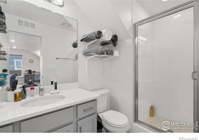 bathroom with an enclosed shower, vanity, and toilet