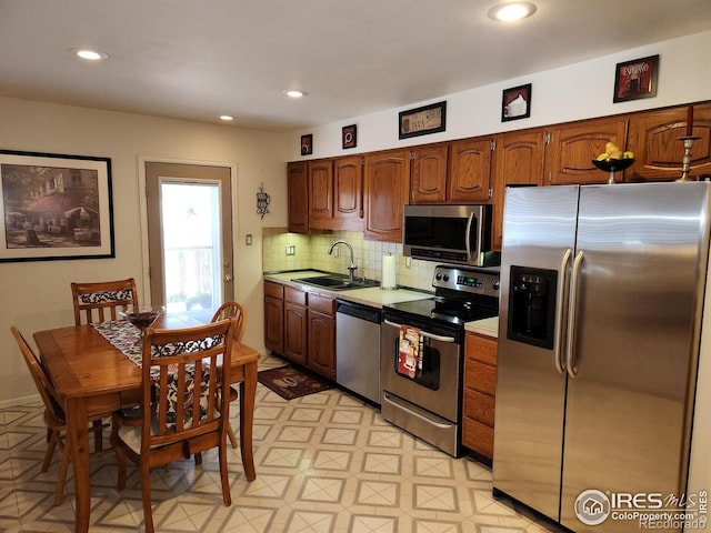 kitchen featuring stainless steel appliances, sink, and decorative backsplash