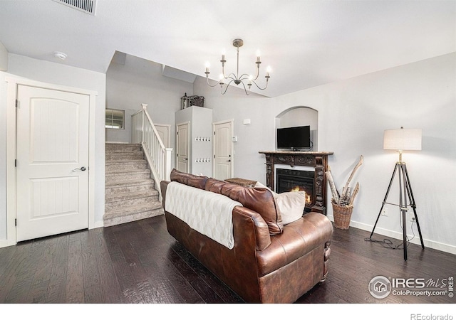 living room featuring dark hardwood / wood-style flooring, vaulted ceiling, and a notable chandelier