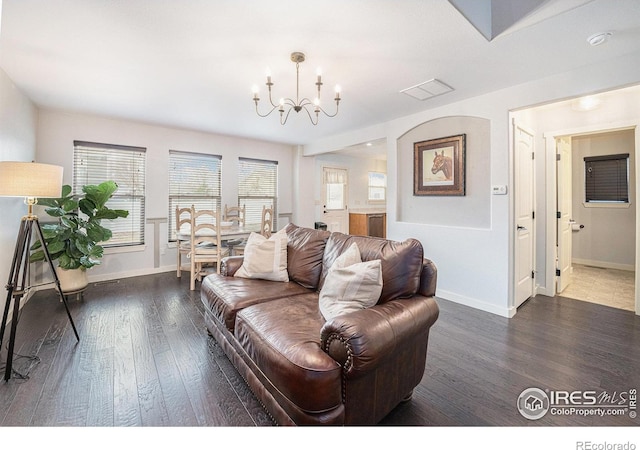 living room featuring an inviting chandelier and dark hardwood / wood-style floors